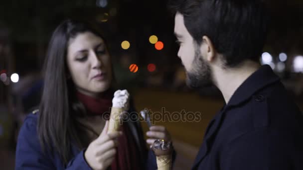 Portrait de couple souriant heureux debout dans la rue mangeant de la crème glacée — Video