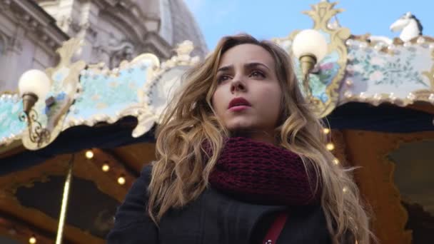 Sérieux, femme réfléchie qui attend quelqu'un, fond de carrousel — Video