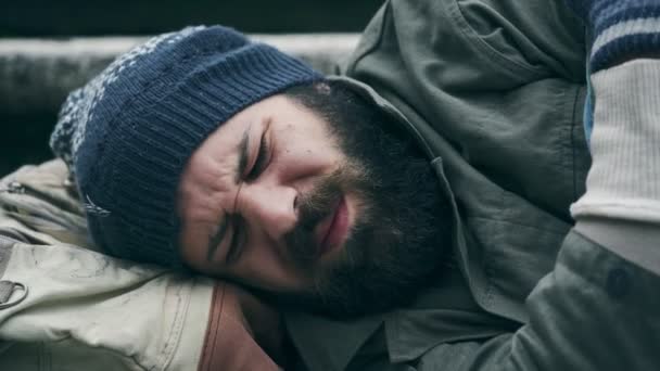 Obdachloser schläft, während der Fußgänger ihn weckt und Almosen hinterlässt