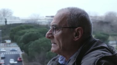 Düşünceli yaşlı adam sigara sigara, şehir arka plan
