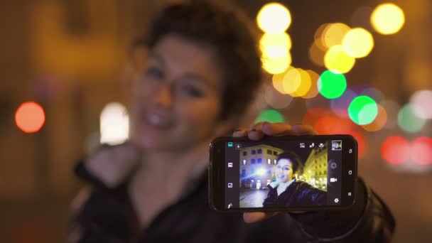 Mujer sonriente toma selfie con teléfono inteligente, de cerca — Vídeo de stock