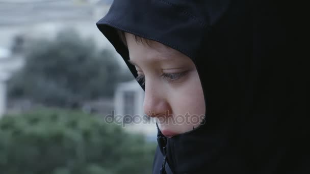 Закрыть грустного и заботливого ребенка с капюшоном — стоковое видео