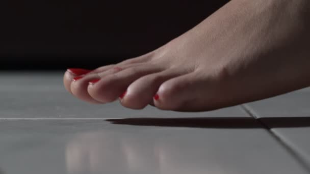 Γυμνά πόδια της γυναίκας με κόκκινο βερνίκι που περπατούν στο πάτωμα νυχιών, εσωτερικη — Αρχείο Βίντεο