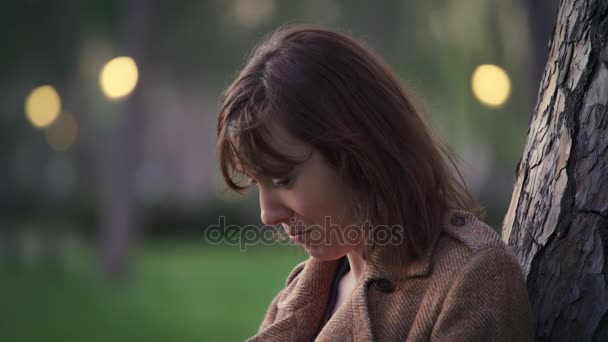 Mujer triste y sola llorando apoyada en un árbol — Vídeos de Stock