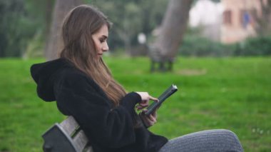 Bankta gülümseyen güzel kadın tablet, profil kullanır