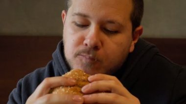 Hırslı bir burger kapmak aç bir adam üzerinde kapat