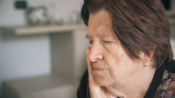 Närbild porträtt av en gammal kvinna fundersam och tråkigt hemma: tankeväckande äldre — Stockvideo
