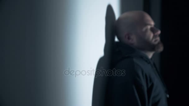 Homem careca encostado à parede intimating parar na câmera — Vídeo de Stock