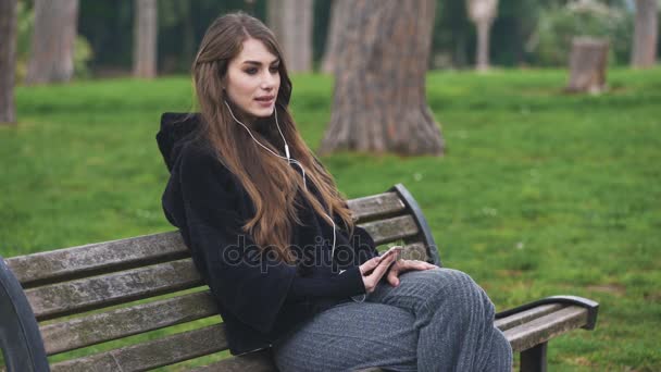 電話での会話のベンチに座っているかわいい女性 — ストック動画
