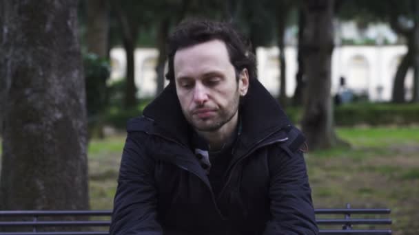 Sad and desperate man sitting on the bench looking up — Stock Video