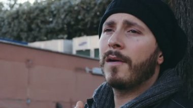 düşünceli adam sigara üzerinde bir sigara bir ağacın altında yakın çekim