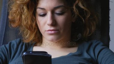 Ciddi ve düşünceli bir genç kadın smartphone kullanır