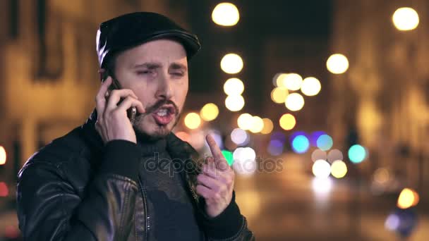 Uomo nervoso e stressato che parla al cellulare in strada di notte — Video Stock