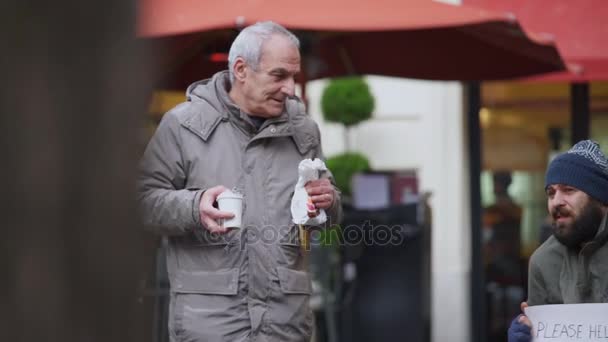 Hongerige eenzaam daklozen ontvangt ontbijt van een oude man — Stockvideo