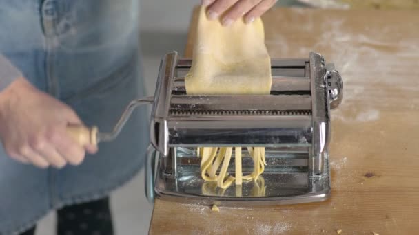 Dona de casa corta a massa para fazer o fettuccine com a máquina — Vídeo de Stock