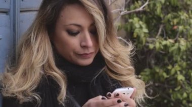 Sarışın kadın ile smartphone açık bir mesaj yazma üzerinde duruldu