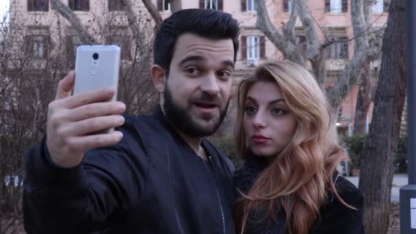 Hermosa pareja enamorada haciendo un divertido selfie, en un parque — Vídeos de Stock