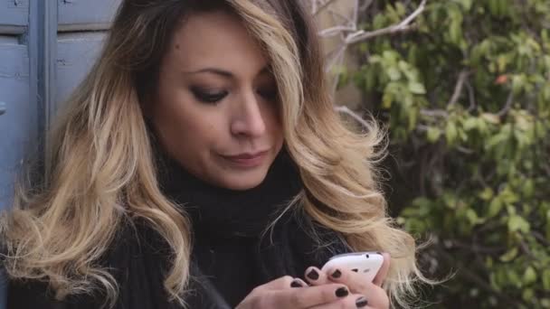 Ξανθιά γυναίκα επικεντρώθηκε σε γράφοντας ένα μήνυμα με τα smartphone-Υπαίθριος — Αρχείο Βίντεο