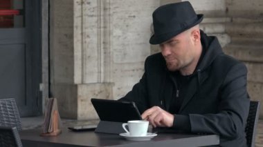 Siyah şapkalı tablet ve gülümsüyor yazarak rahat adam