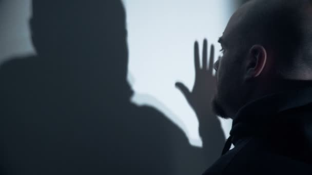 Triste hombre calvo toca su sombra reflejada en la pared — Vídeos de Stock