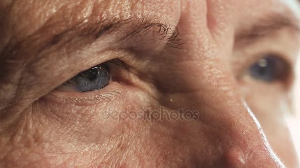 Голубые глаза заботливой пожилой женщины, закрой — стоковое видео