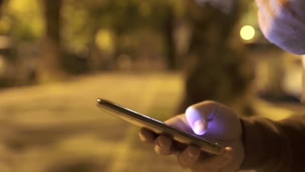 Perfil de mão homem digitando no smartphone à noite — Vídeo de Stock