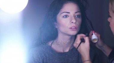 Sanatçı makyaj fırçası ile kırmızı ruj youn esmer'ın dudaklarından geçerlidir.