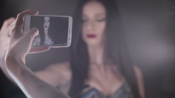 Красивая и утонченная женщина делает селфи перед зеркалом — стоковое видео