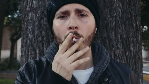 Vážně hrdý mladý muž při pohledu na fotoaparát kouření cigaret — Stock video