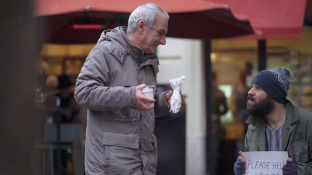 Hungry lonely  homeless receives breakfast from an old man — Stock Video