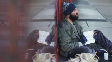 sokakta oturan üzgün evsiz bir yaya ona para verir