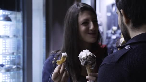 Gelukkige paar in de straat, glimlachend en het eten van ijs-steady cam chatten — Stockvideo