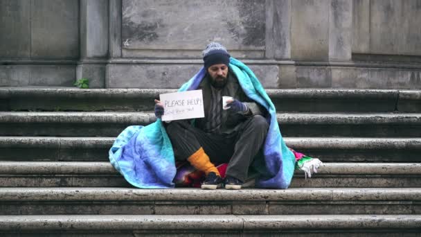 Porträt trauriger Obdachloser, die allein auf der Treppe eines Brunnens auf Almosen warten — Stockvideo