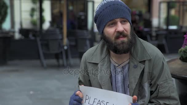 Viejo caballero ofrece un croissant y un café caliente a un indigente en la calle — Vídeo de stock