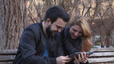 Portresi eğlenceli, çift tablete fotoğraflarına bakmaktan tezgah üzerinde gülümseyen