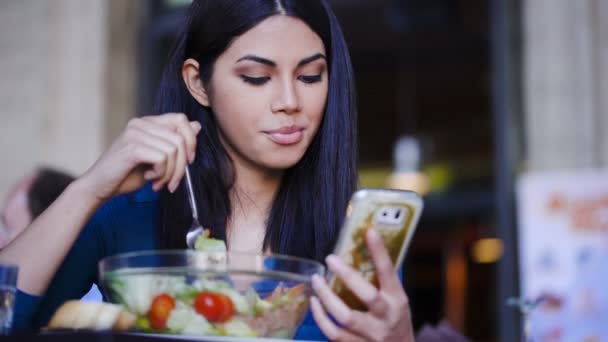 웃는 아름 다운 필리핀 여성 샐러드 먹고 핸드폰에 읽기 — 비디오