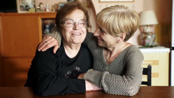 Счастливые женщины семейный портрет: дочь обнимает и целует старую мать — стоковое видео