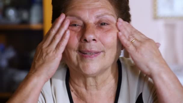 Velha Senior mulher descobrindo seus olhos e feliz sorrindo para a câmera — Vídeo de Stock