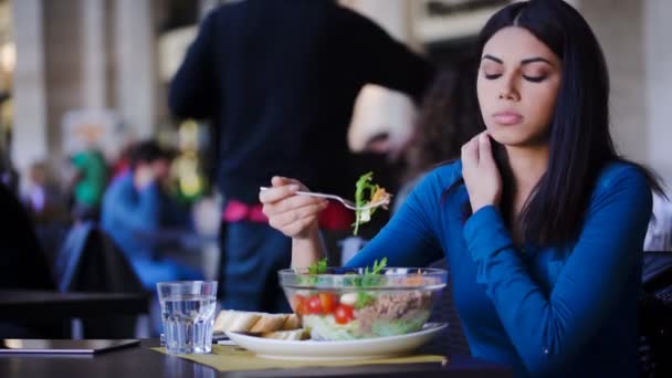 Ensam fundersam asiatisk kvinna äta sallad i en restaurang — Stockvideo