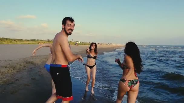 Zomervakantie: vier vrienden lopen zorgeloos aan de kust — Stockvideo