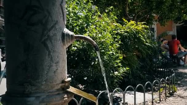 Perto em Atleta enxaguando as mãos e bebendo de uma fonte antiga em uma cidade — Vídeo de Stock