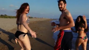 Yaz günlerinde: mutlu çekici genç arkadaş On The Beach çalıştıran eğlenmek 