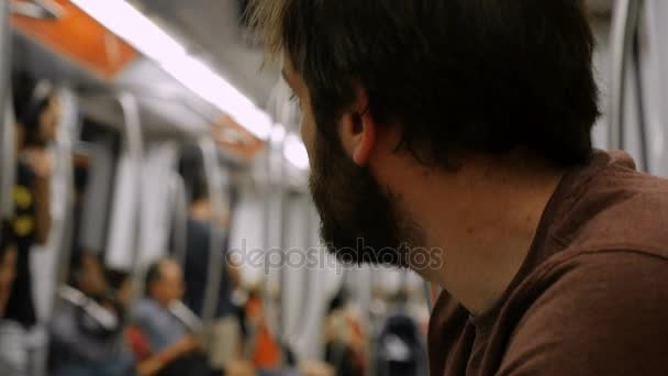 Passagerare med ett skägg som sitter i trånga tunnelbanan väntar hans stopp, Rom, Italien, juni 2017 — Stockvideo
