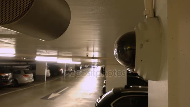 Câmera de vídeo de vigilância na parede olhando veículos no estacionamento interior — Vídeo de Stock