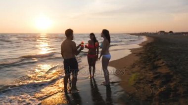 Yaz tost: 4 arkadaşlar tezahürat neşeyle gün batımında deniz kıyısı