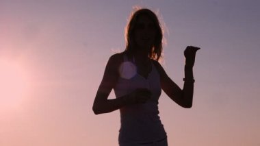 Siluet, seksi kadın dans sırasında güzel gün batımı