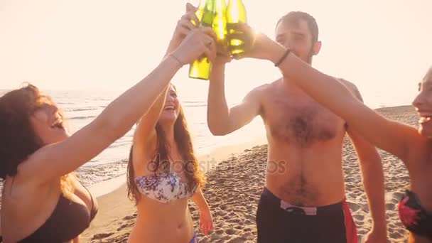 Hora de verano: Smiling Friends Clinks cerveza Botellas en la playa al atardecer — Vídeos de Stock