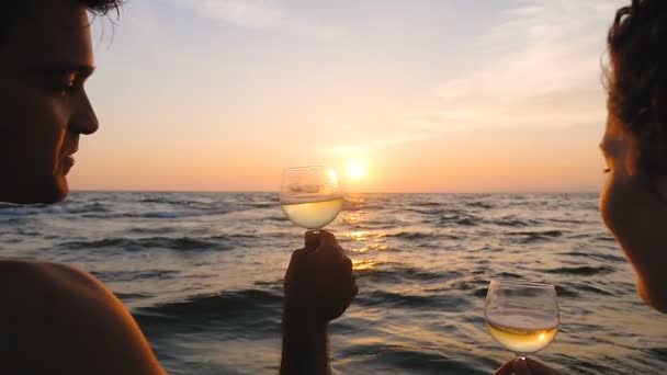 Casal romântico brindando na praia assistindo o pôr do sol sobre o mar — Vídeo de Stock