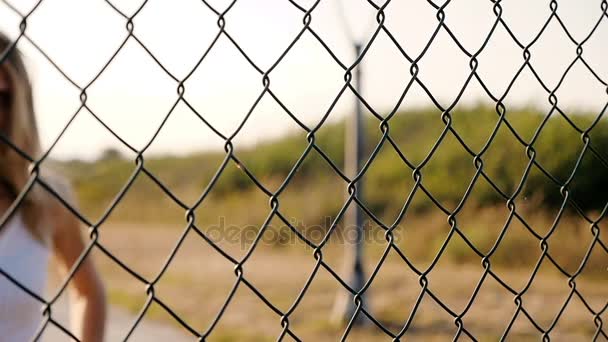 Mujer triste y solitaria borrosa sosteniendo la red al aire libre — Vídeos de Stock