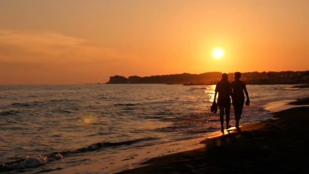 Sommar romantisk solnedgång: par promenad på stranden — Stockvideo